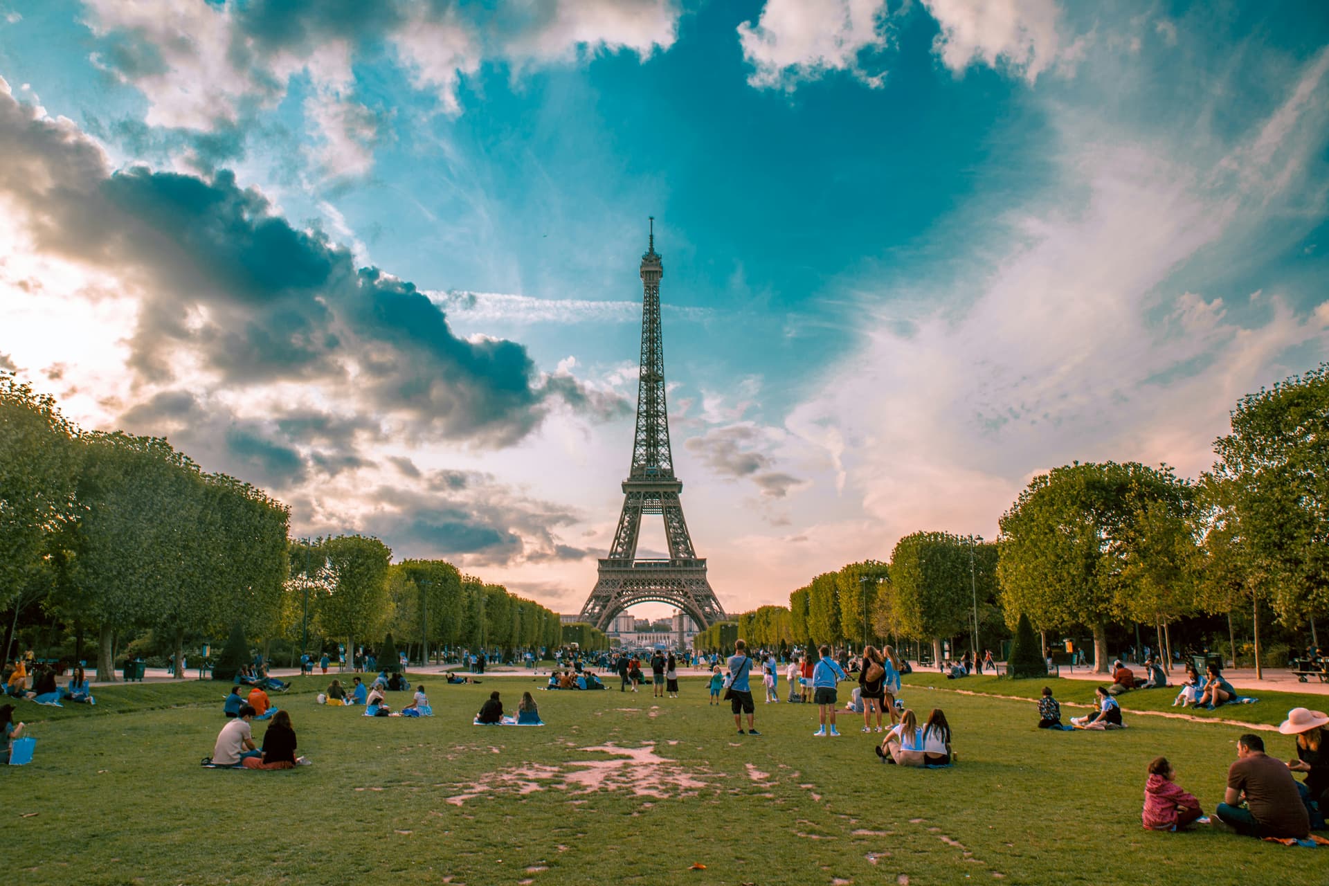 Family visiting Eiffel Tower and Champ de Mars gardens in Paris