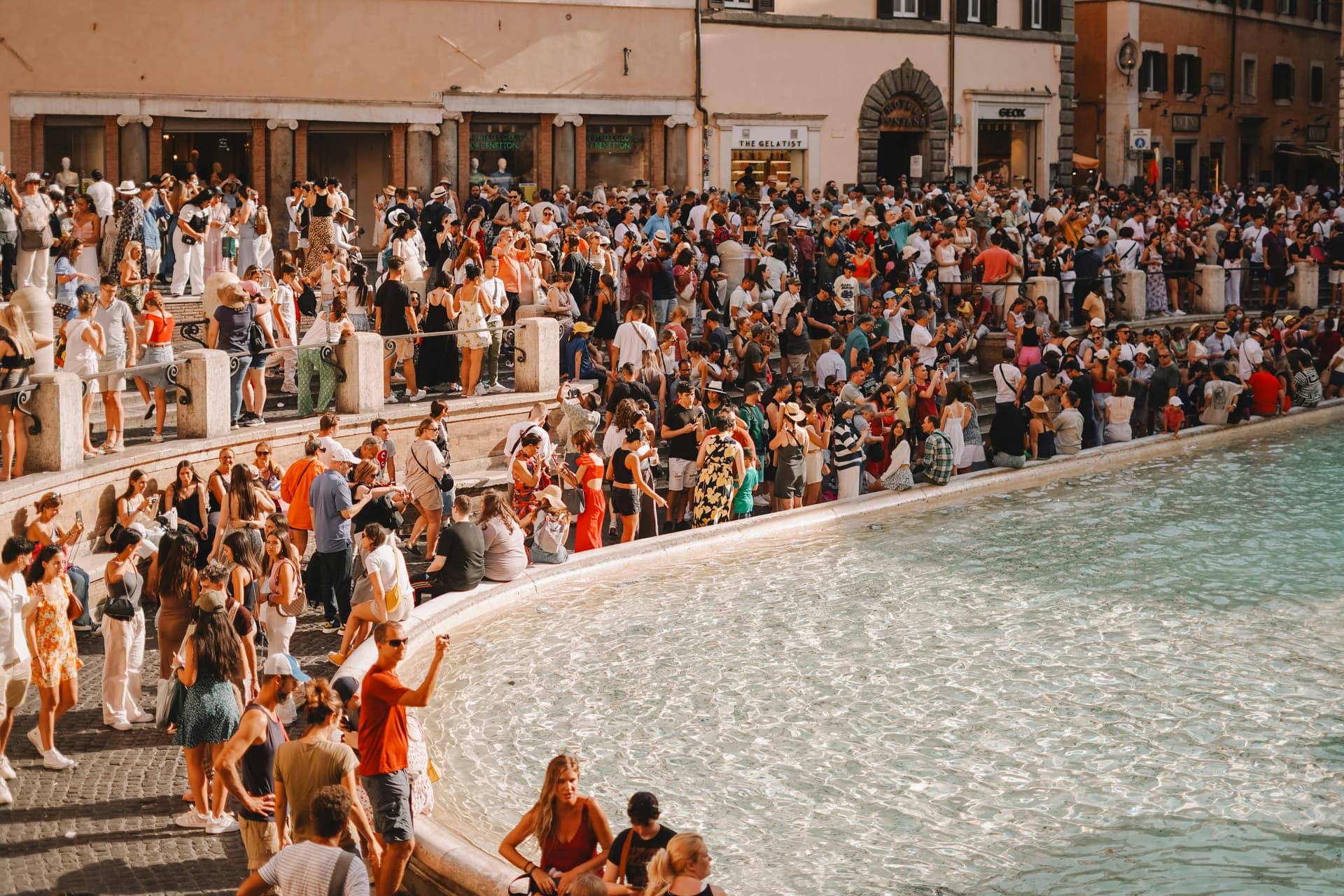 Couple tossing coins into the Trevi Fountain in Rome