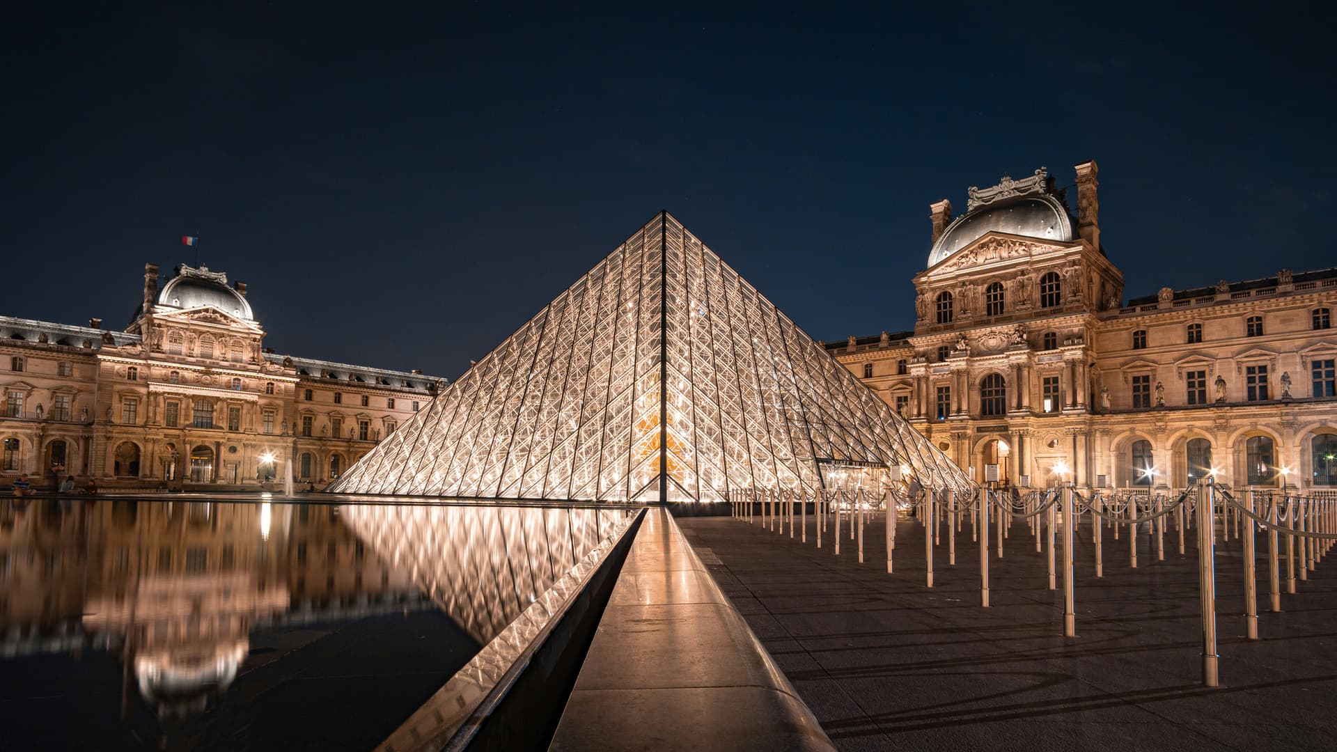 Family outside Louvre Museum in Paris with pyramid in background